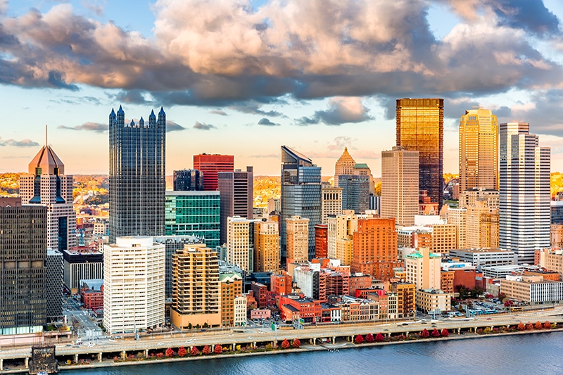 Pittsburgh downtown under a warm sunset light, viewed from Grandview Overlook across Monongahela River